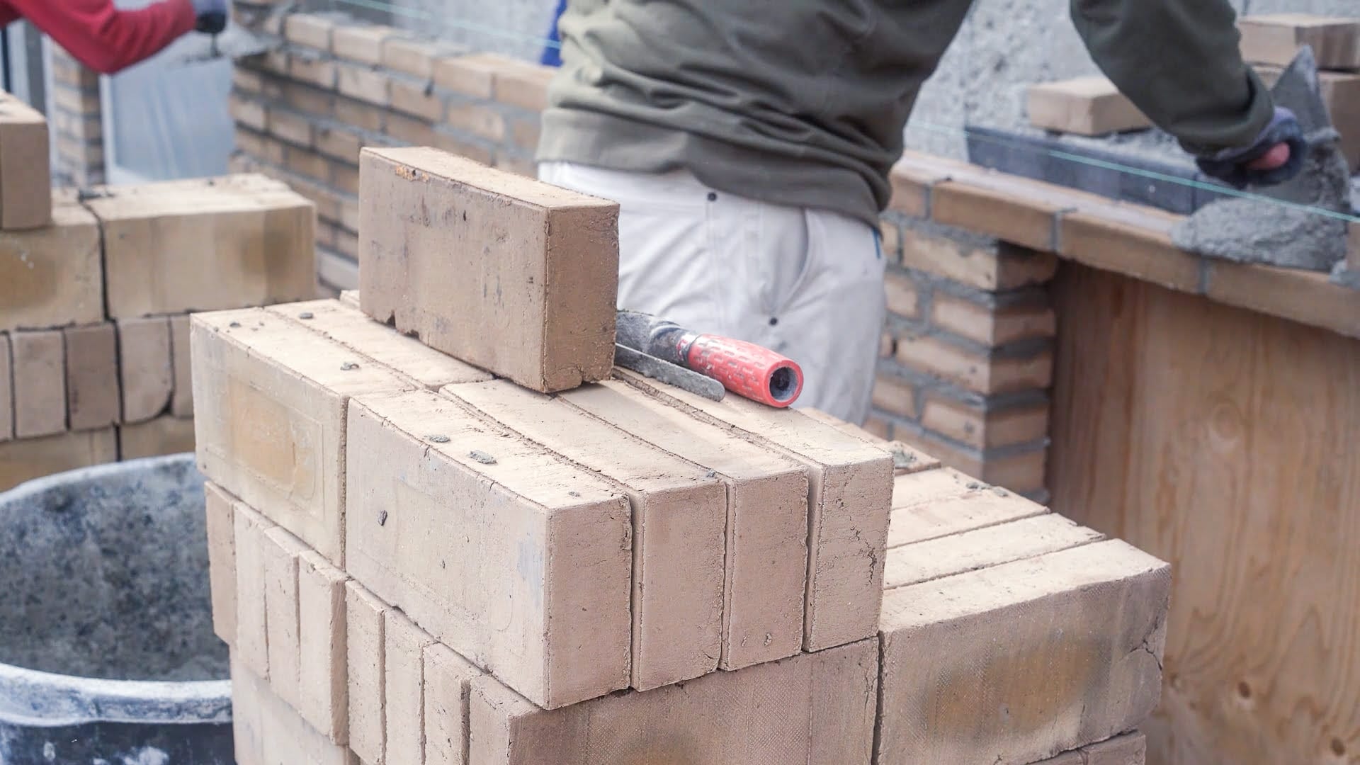 Murer arbejder med mursten og mørtel