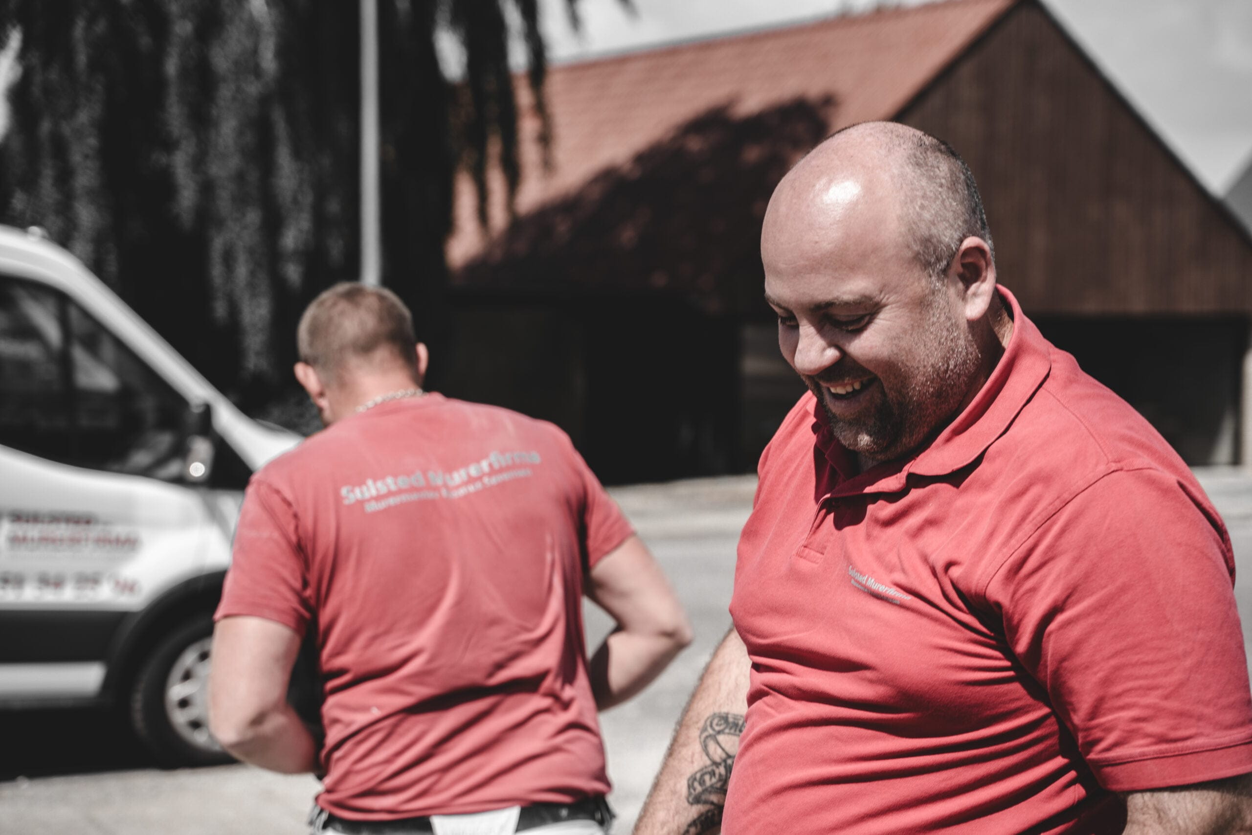 To håndværkere arbejder udendørs en solrig dag