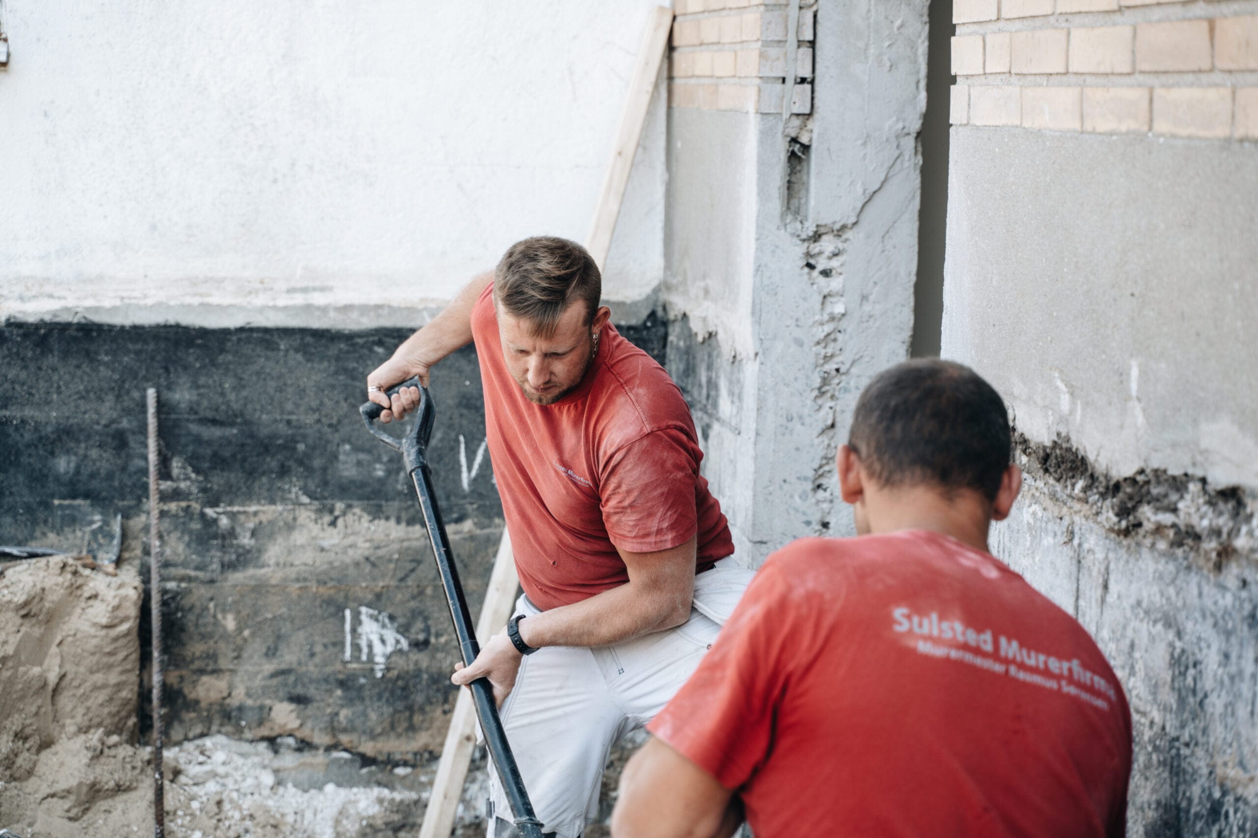 Murere arbejder på renovering af husfacade