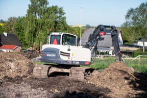 Gravemaskine arbejder på en byggeplads i landsbyen