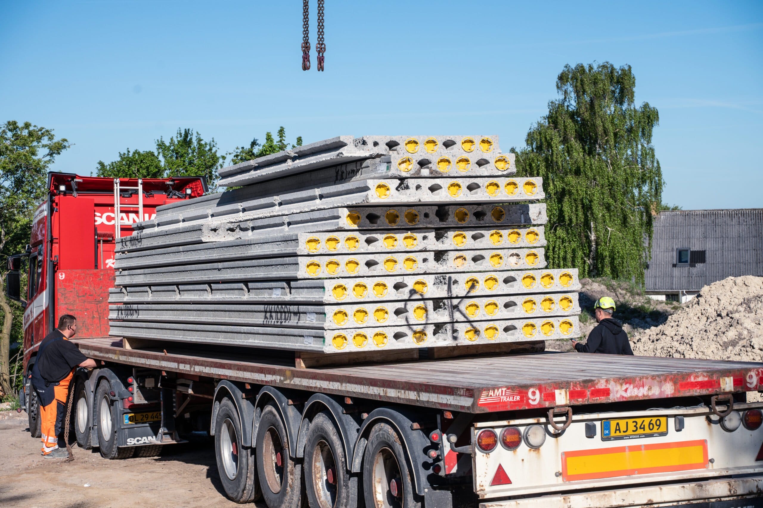 Lastbil transporterer præfabrikerede betonelementer på byggeplads