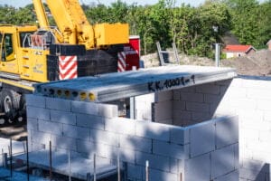 Kran løfter betondæk på byggeplads