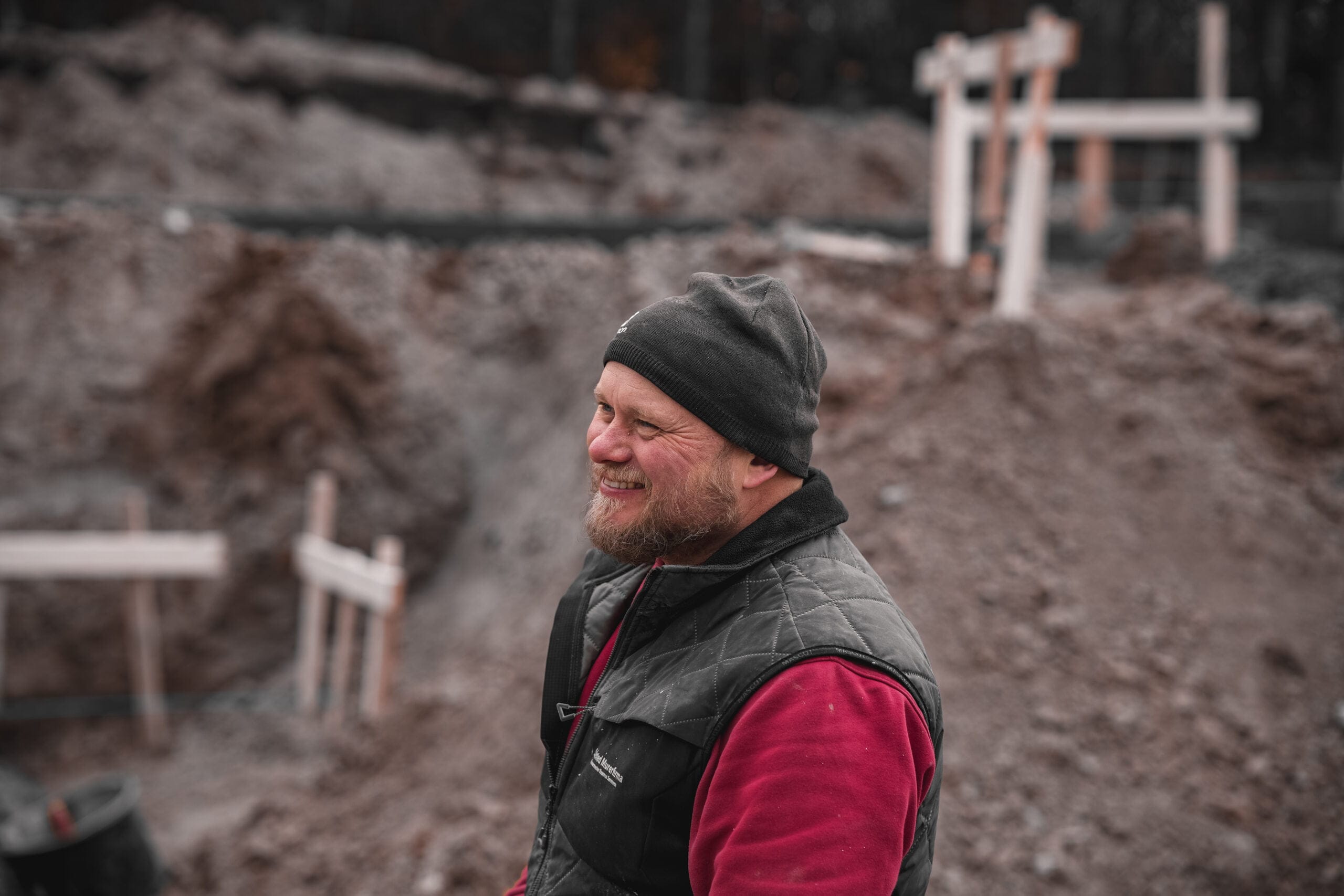 Smilende bygningsarbejder på byggeplads
