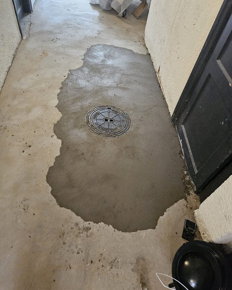 Nylagt beton omkring gulvafløb i gang