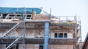 Bygning under renovering med stillads og presenning