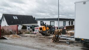 Byggeplads foran huse med maskiner og materialer