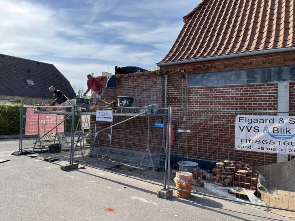 Murere arbejder på murstensbygning under renovering