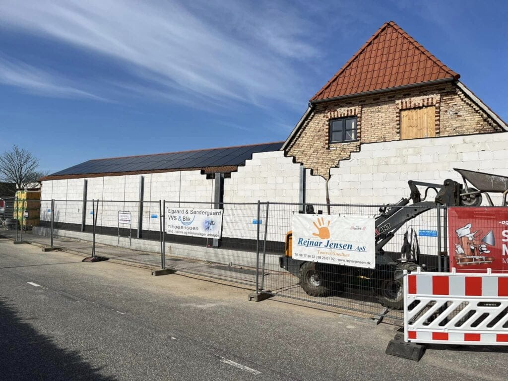 Bygning under renovering med stillads og udstyr foran