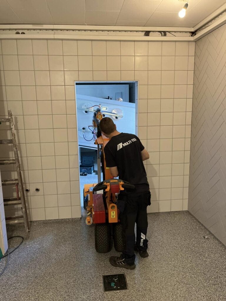 Håndværker installerer glasvæg med maskine i badeværelse