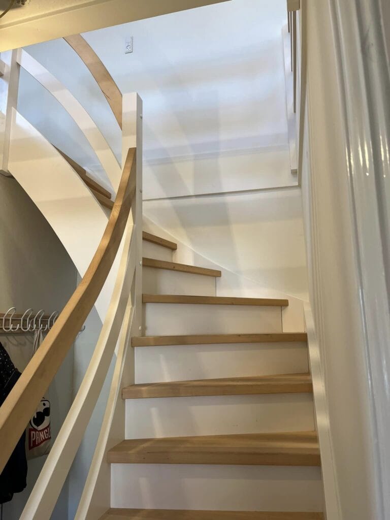 Moderne trappe med lyse trætrin og hvidt gelænder