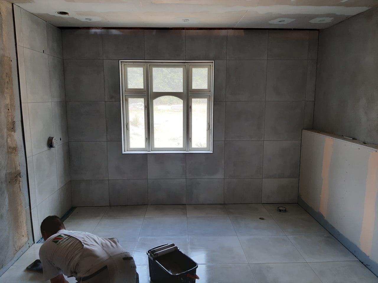 Håndværker lægger fliser i nyt badeværelse