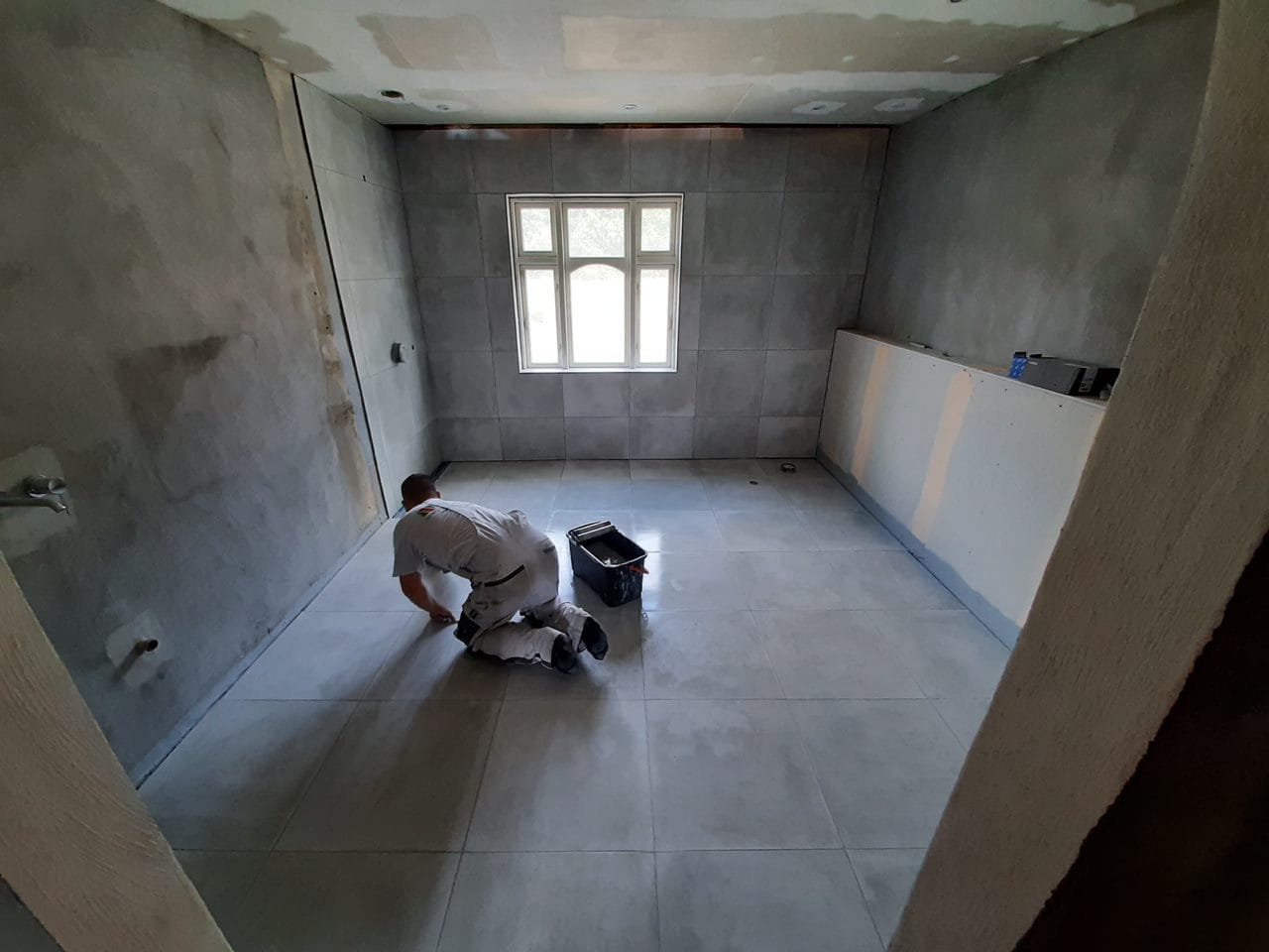 Håndværker lægger fliser i nyt badeværelse