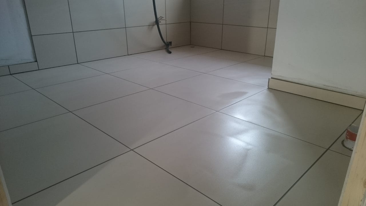 Nylagt lysegråt flisegulv i badeværelse