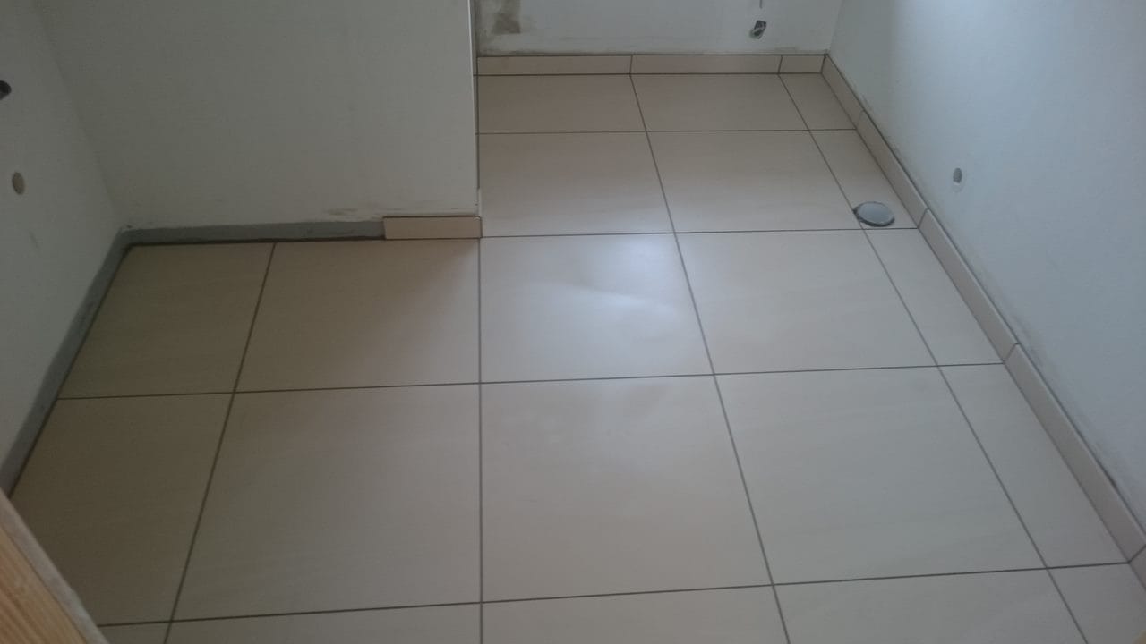 Lyst flisegulv i lille badeværelse under renovering