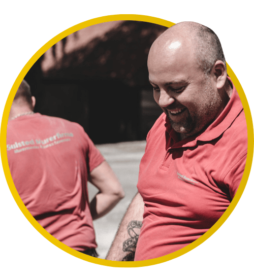 Smilende håndværker i rød polo arbejder udendørs